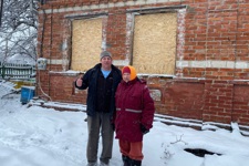 Пасічник та його мати біля пошкодженого будинку з забитими вікнами