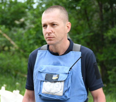 Портрет демінера в захисному спорядженні на фоні зелені