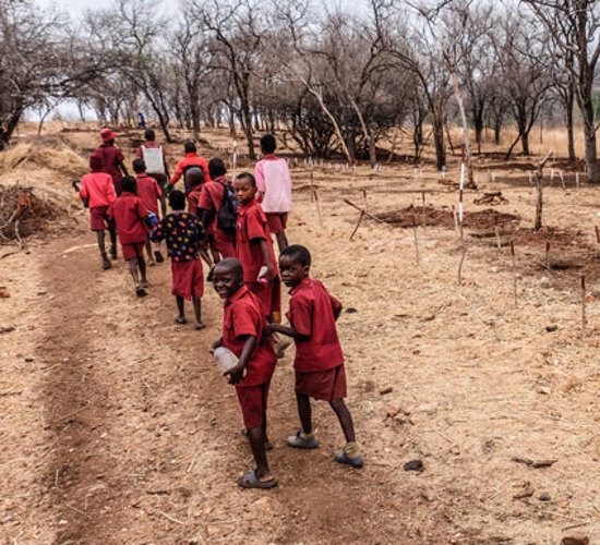 Children pass through a minefield on their way to school in Zimbabwe