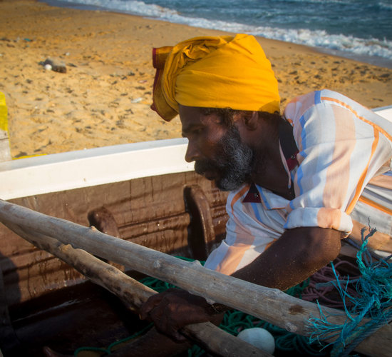 Terunavakarasu, a Sri Lankan fisherman sits in his fishing boat on the beach