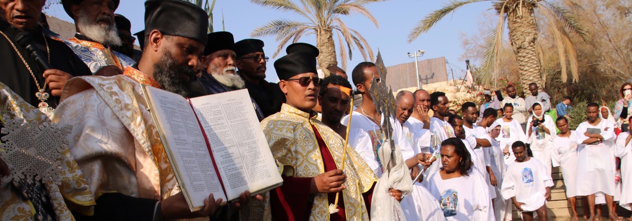 Clergy lead a solemn procession during the epiphany service at the Baptism site, dressed in traditional robes.