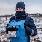 Дівчина-демінерка в балаклаві на фоні зимного поля