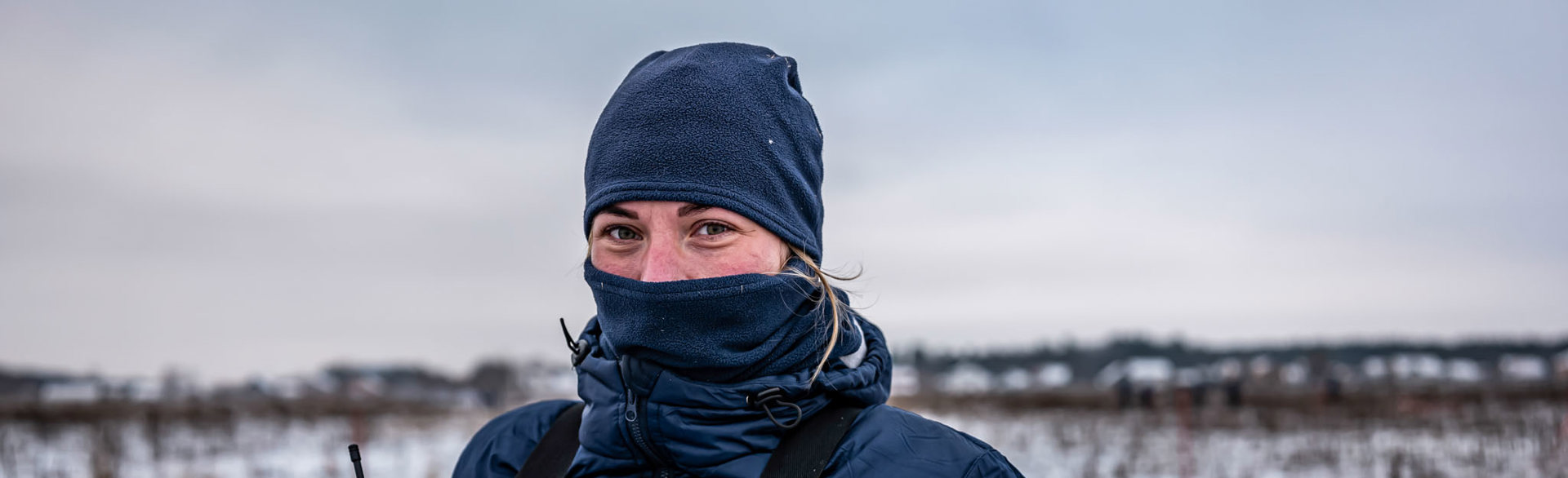 Дівчина-демінерка в балаклаві на фоні зимного поля