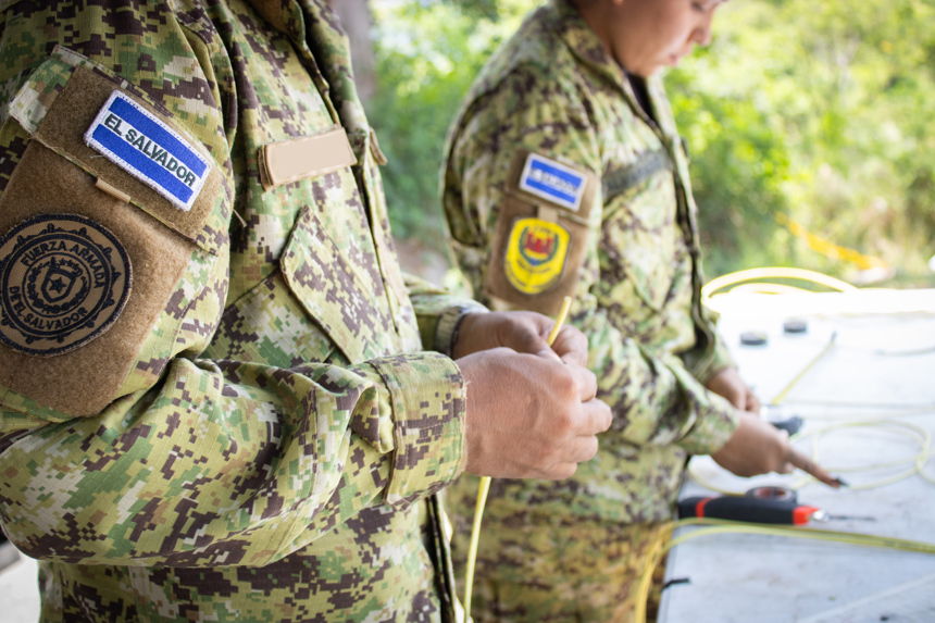 Two members from El Salvador's Armed Forces hold wires as they do explosive ordnance disposal training