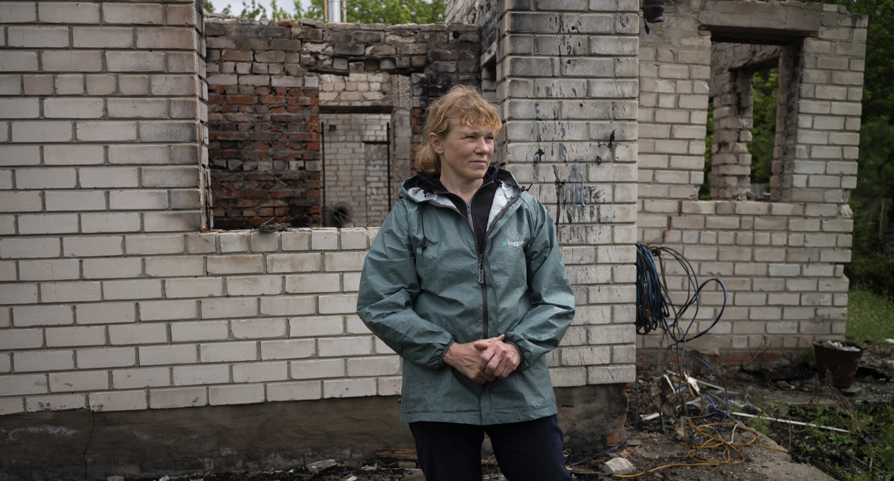 Наталя навпроти свого зруйнованого росіянами будинку