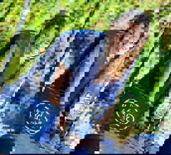 Maria wears a HALO vest as she writes on a clipboard