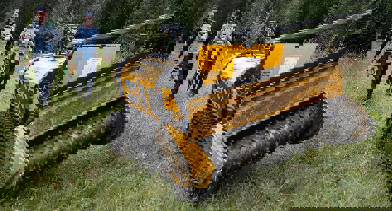 Фотографія машини для видалення рослинності дистанційно на фони смуги дереві і двох  демінерів