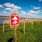 Промаркований знаками мінної небезпеки берег річки