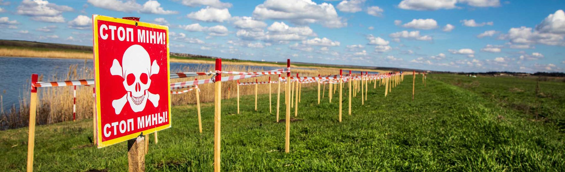 Промаркований знаками мінної небезпеки берег річки