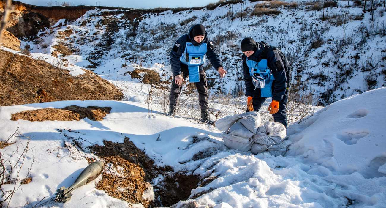 Спеціалісти зі знешкодження боєприпасів готуються до ліквідації боєприпасу, обкладаючи місце підриву мішками