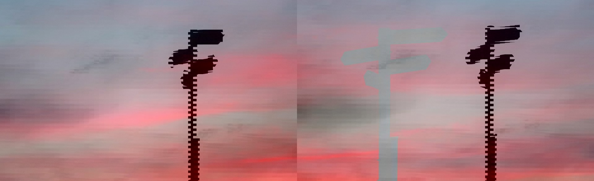 Directional sign with a sunset behind it