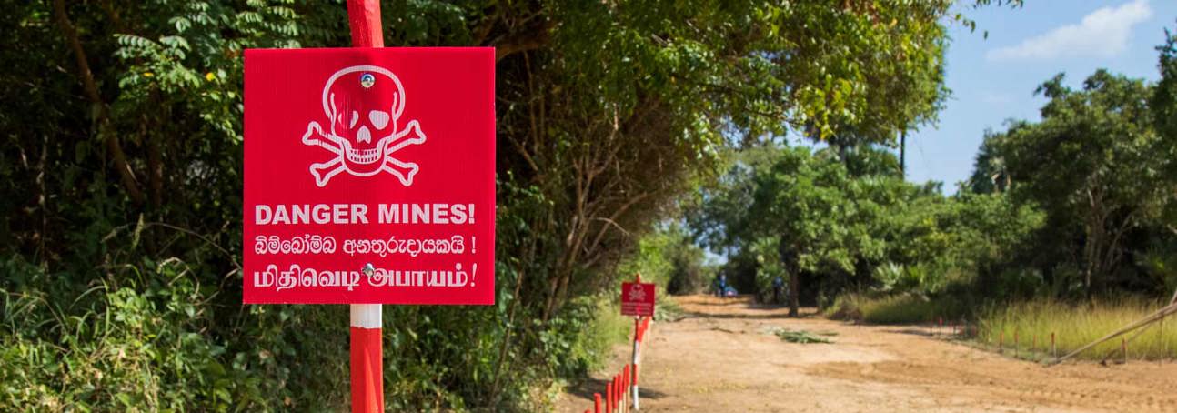A red danger mines sign in Muhamalai minefield, Sri Lanka