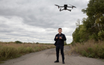 Пілот дрону проводить розвідку щодо наявності мінної загрози в полях поблизу дороги