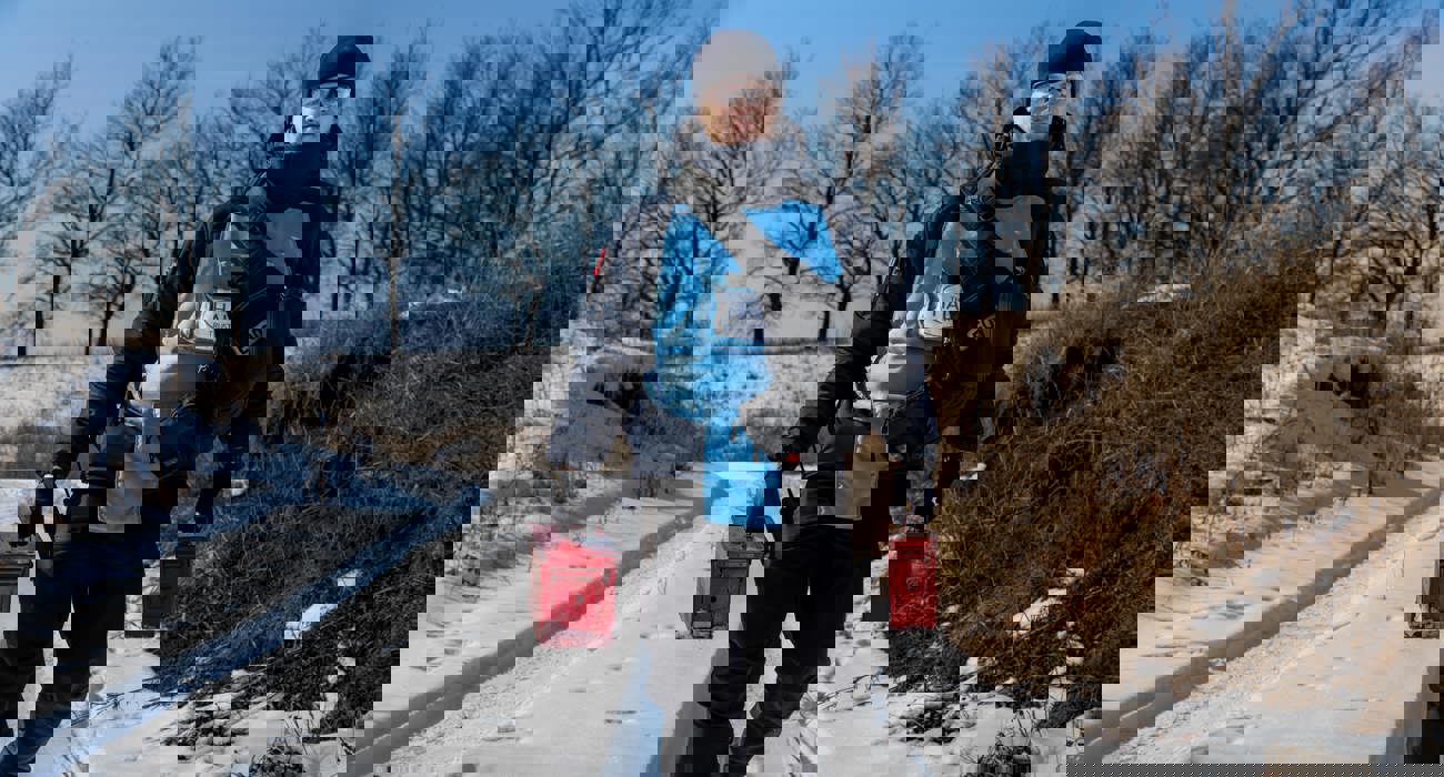 Спеціаліст зі знешкодження боєприпасів йде назустріч з двома червоними коробками з вибухівкою для проведення знешкодження боєприпасів