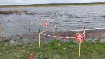 Fenced off landmines and explosive contamination in a flooded field in Kherson Oblast, Ukraine