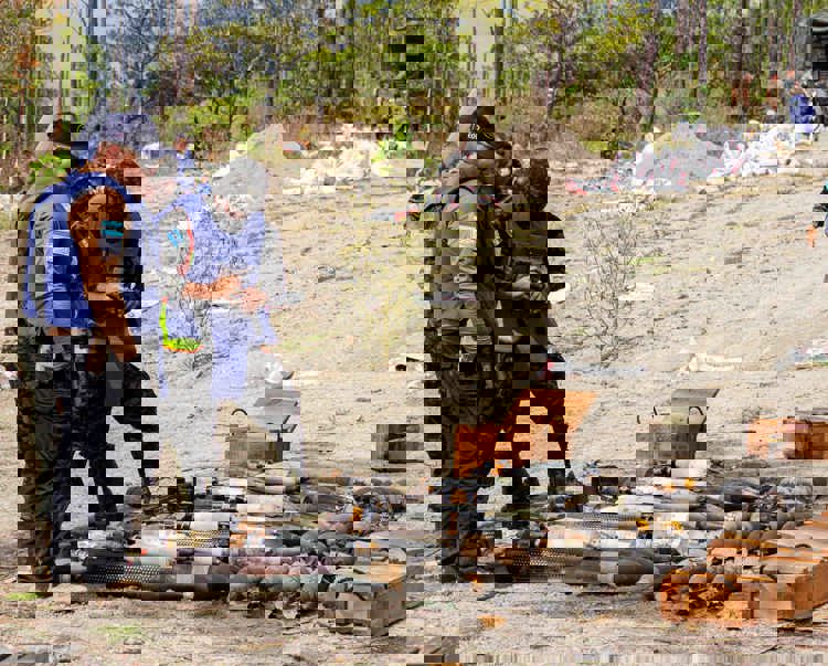 People in HALO vests gather round a stockpile of weapons in Honduras