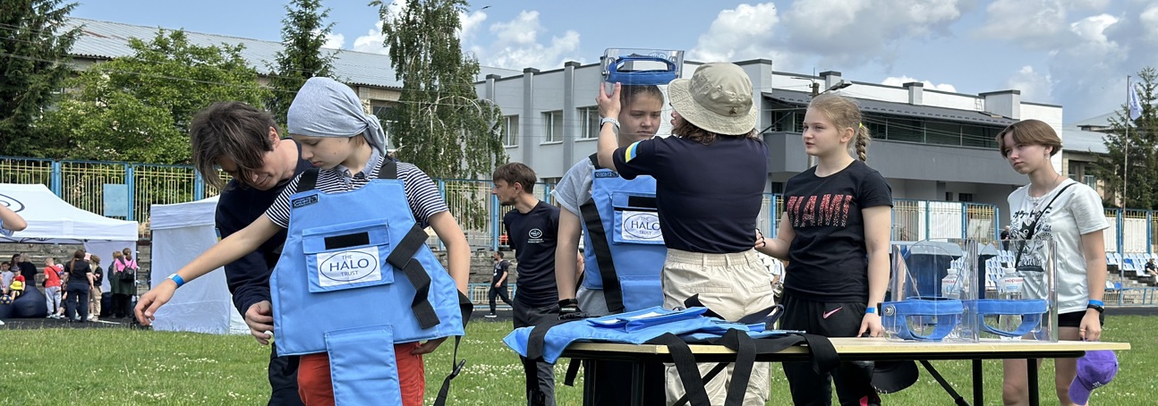 Діти приміряють захисне спорядження демінера під час уроків обізнаності про мінну небезпеку