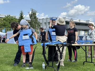 Діти приміряють захисне спорядження демінера під час уроків обізнаності про мінну небезпеку