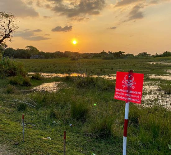 A flooded minefield in Sri Lanka with the sun setting in the background
