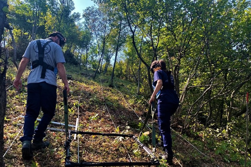 Battle area clearance technicians map the ground in a forest