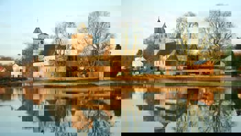 Old church of Oosterbeek, a Battle of Arnhem monument, reflected in the River Rhine