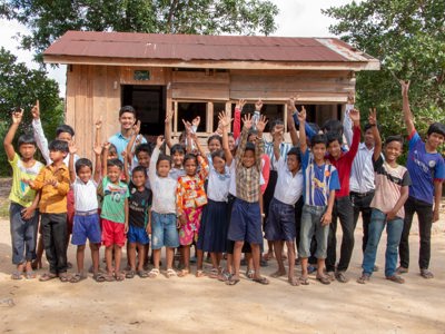 A large group of children waving in Cambodia