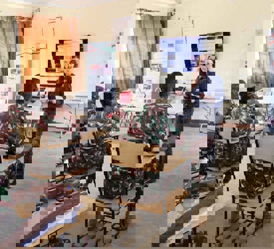 Military personnel sit in a weapons management class