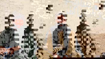 Two men sitting in front of a wall in Helmand Province