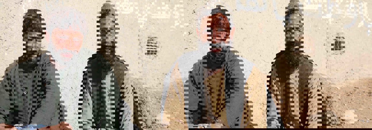 Two men sitting in front of a wall in Helmand Province